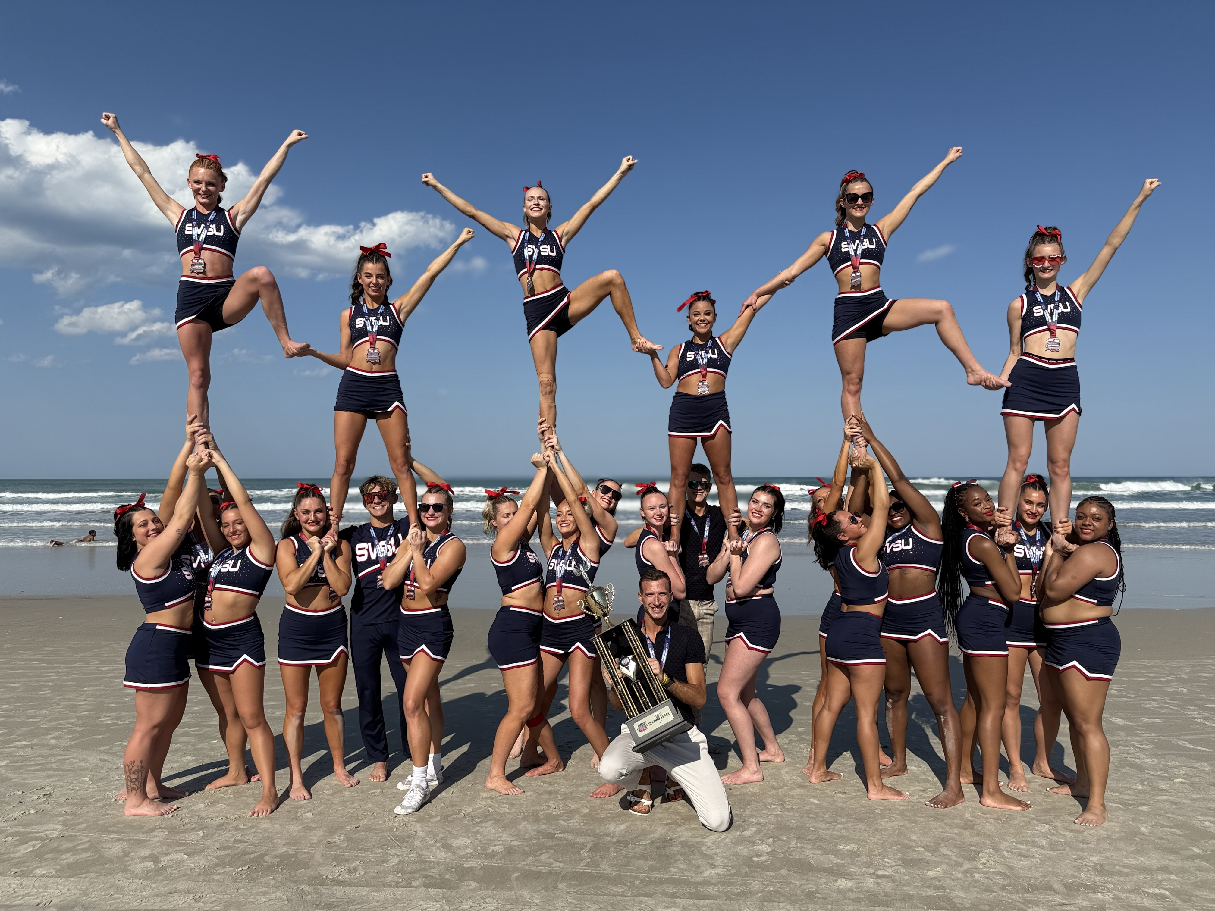 cheerleaders in blue uniforms in formation on waterfront